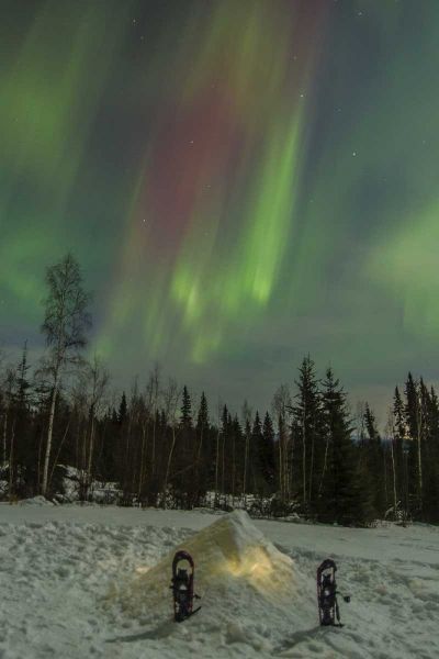 AK A quinzee snow shelter and aurora borealis